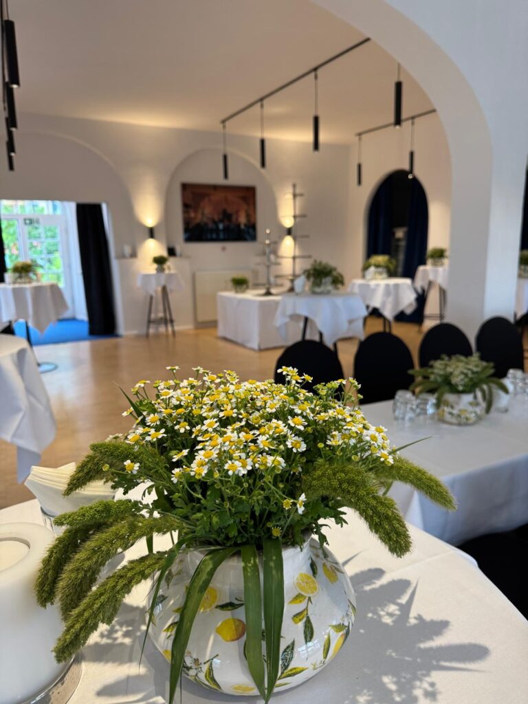 Blumengedeckte Tische im Blauen Saal