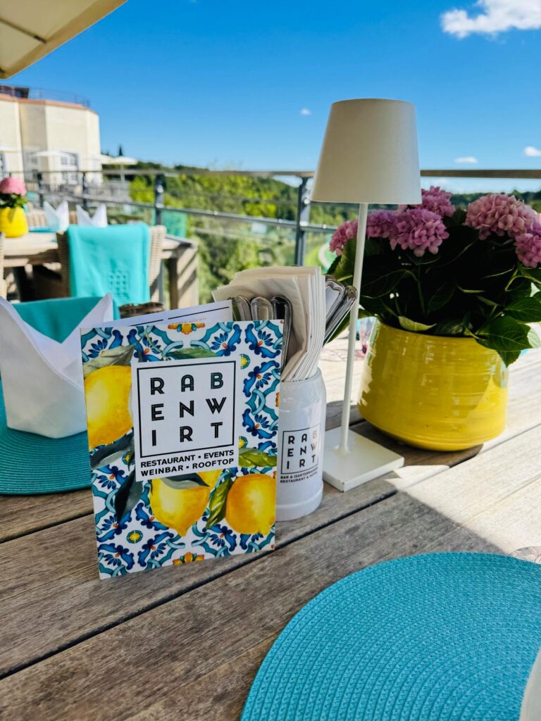 Ein sonniger Terrassentisch mit Getränkekarte